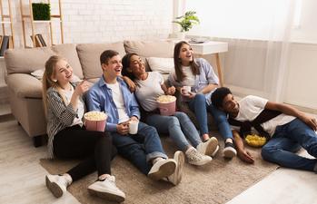 Netflix Viewers: Check Your Email. The Password Sharing Crackdown Has Begun.: https://g.foolcdn.com/editorial/images/733707/a-group-of-young-friends-sitting-on-the-floor-watching-television.jpg