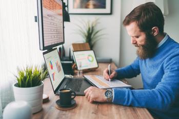 Is Okta Stock a Buy Now?: https://g.foolcdn.com/editorial/images/733490/bearded-person-at-desk-by-computer-taking-notes.jpg