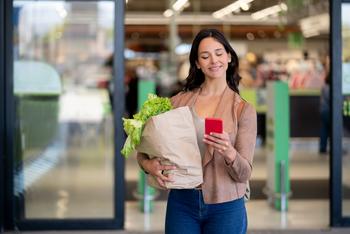 Better Buy: Amazon vs. Costco: https://g.foolcdn.com/editorial/images/717133/a-person-holdings-a-bag-of-groceries-outside-of-a-store-and-also-holding-a-mobile-phone.jpg