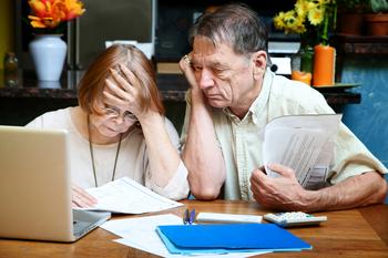 What Are Your Options if You Haven't Saved Enough When You Retire?: https://g.foolcdn.com/editorial/images/761980/senior-couple-worried-looking-at-bills-finances-debt.jpg