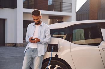 1 Revolutionary Electric Vehicle Stock Down 95% to Buy Hand Over Fist Right Now: https://g.foolcdn.com/editorial/images/766136/getty-images-driver-uses-a-smartphone-while-waiting-for-an-ev-to-charge.jpg