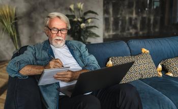 If You Delay Retirement, Should You Also Delay Claiming Social Security?: https://g.foolcdn.com/editorial/images/690635/senior-holding-laptop-and-writing-note-in-notebook.jpg