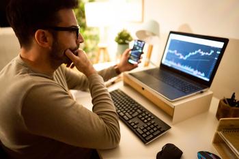 1 Beaten-Down Tech Stock to Buy Hand Over Fist Before It Erupts: https://g.foolcdn.com/editorial/images/745026/man-in-specs-holding-a-phone-and-looking-at-a-chart-on-a-laptop.jpg