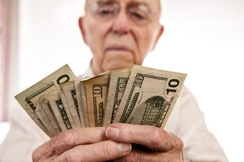 Who's Ready for a $6,638 Social Security Benefit Cut?: https://g.foolcdn.com/editorial/images/766775/senior-fanning-cash-retirement-social-security-getty.jpg