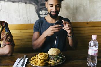 Is It Too Late to Buy Cava Stock?: https://g.foolcdn.com/editorial/images/789057/guy-taking-photo-of-burger.jpg