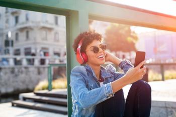 3 Reasons to Buy AT&T, and 1 Reason to Sell: https://g.foolcdn.com/editorial/images/703657/woman-with-headphones-looking-at-mobile-phone-outdoors_gettyimages-1134003609.jpg