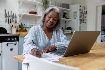 Want to Build a Millionaire Retirement? Consider These 7 Moves in 2024.: https://g.foolcdn.com/editorial/images/783431/person-in-kitchen-filling-out-documents-in-front-of-her-computer.jpg
