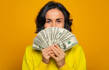 4 Ways to Grow $100,000 Into $1 Million for Retirement Savings: https://g.foolcdn.com/editorial/images/773484/young-woman-holding-a-lot-of-money-gettyimages-1249955556.jpg