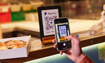 Will PayPal Be a Trillion-Dollar Stock by 2035?: https://g.foolcdn.com/editorial/images/767800/person-at-counter-ordering-food-with-phone-by-scanning-paypal-qr-code_paypal.jpg