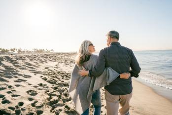 3 Great Reasons to Take Social Security at 62 -- and 1 Reason to Wait: https://g.foolcdn.com/editorial/images/759270/two-people-walking-on-the-beach-hugging.jpg