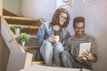 Interest Rates Could Fall in 2024. Is It Time to Buy This Real Estate Technology Stock?: https://g.foolcdn.com/editorial/images/751049/a-smiling-couple-that-just-moved-into-a-new-home-looking-at-a-tablet-device-while-sitting-on-the-stairs.jpg