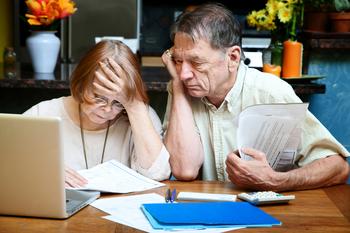 Is a "Backroom Scheme" to Cut Social Security Benefits About to Be Passed?: https://g.foolcdn.com/editorial/images/762476/senior-couple-worried-looking-at-bills-finances-debt.jpg